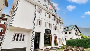 A multi-story hotel with a prominent entrance, balconies, and a clear view of the surrounding landscape. - Collection O Dal Lake (Srinagar)