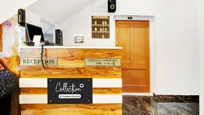A hotel reception desk with a reception sign, a check-in/check-out sign, and a room number sign. - Collection O Dal Lake (Srinagar)