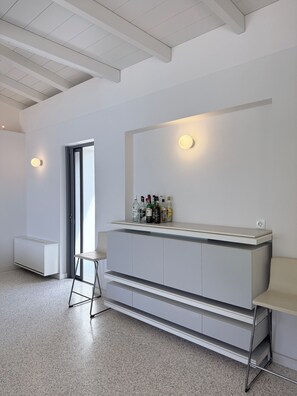 A modern interior with a white console table, a stool, and a built-in cabinet.