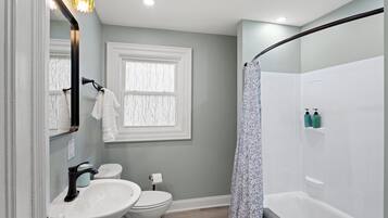 A bathroom with a toilet, sink, and bathtub.