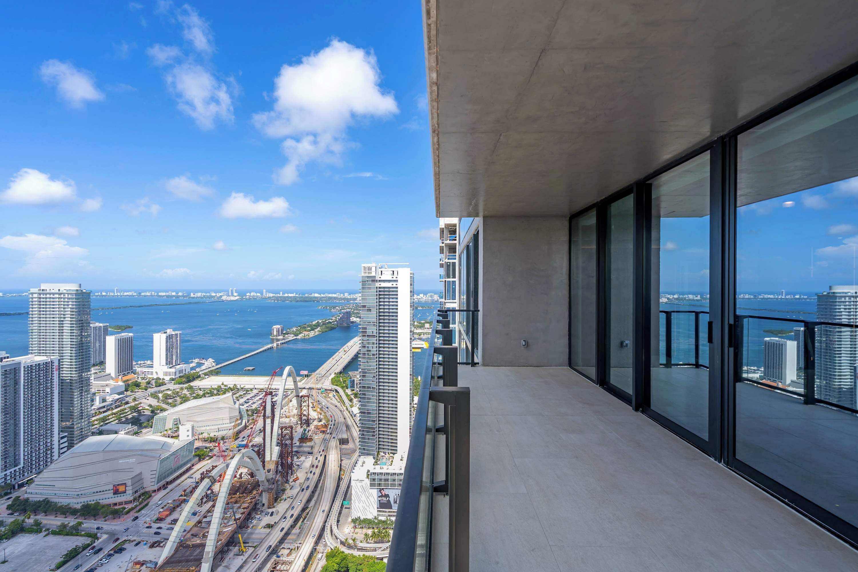 A high-rise building with a view of a cityscape and a body of water.