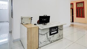 A reception desk with a computer, a telephone, and a sign indicating 'Collection Company-Serviced'. - Collection O Iskcon Temple Mansarovar  (Jaipur)