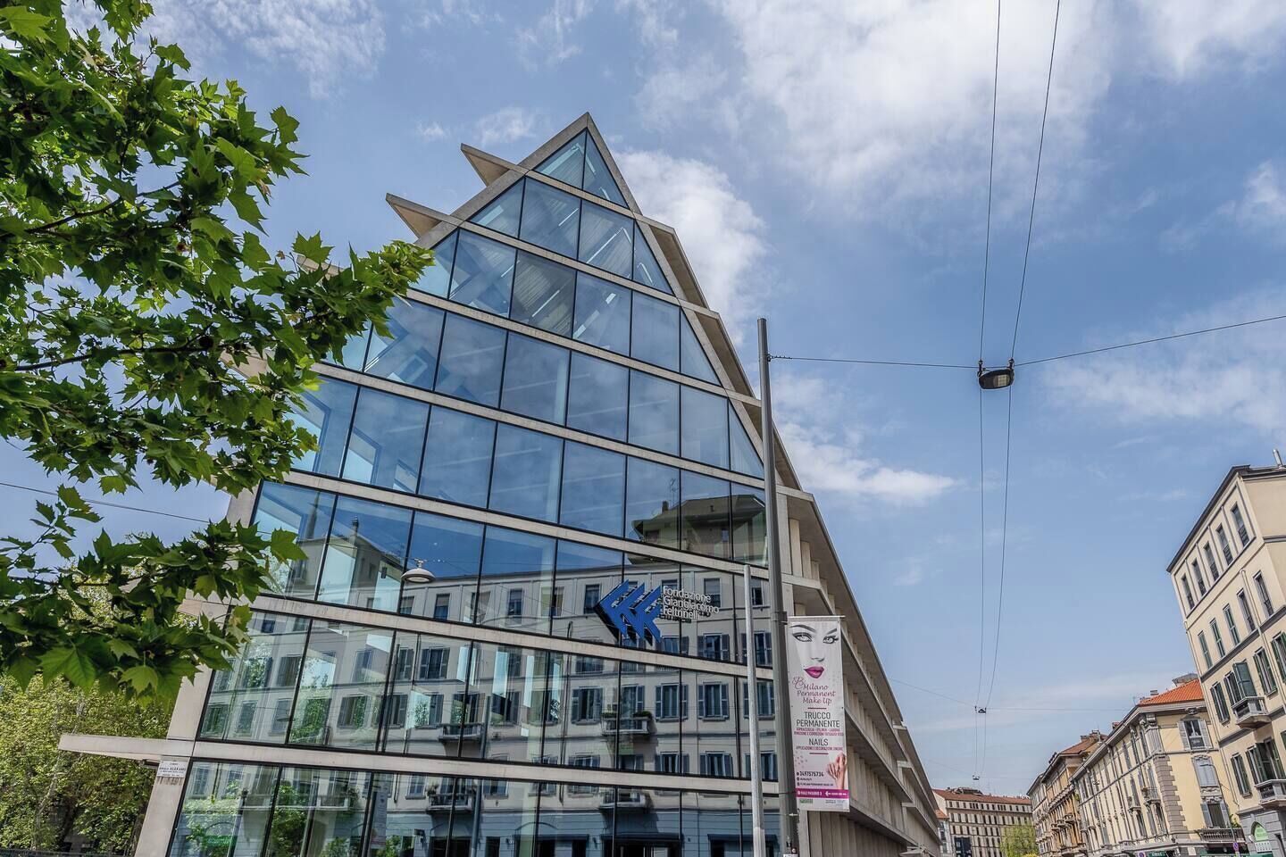 A modern building with a glass facade and a triangular design element.