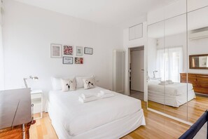 Een moderne hotelkamer met een groot bed, een bureau en een spiegel.