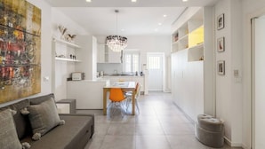 A modern kitchen with a dining area, a sofa, and a large abstract painting. - Garibaldi's Residence (Milan)