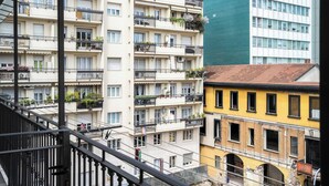 A multi-story residential building with balconies, a staircase, and a contrasting modern building in the background. - Garibaldi's Residence (Milan)