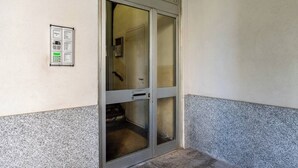A door with a glass panel and a wall-mounted device to the left. - Garibaldi's Residence (Milan)