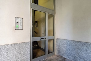 Eine Tür mit Glasscheibe und ein an der Wand befestigtes Gerät auf der linken Seite.