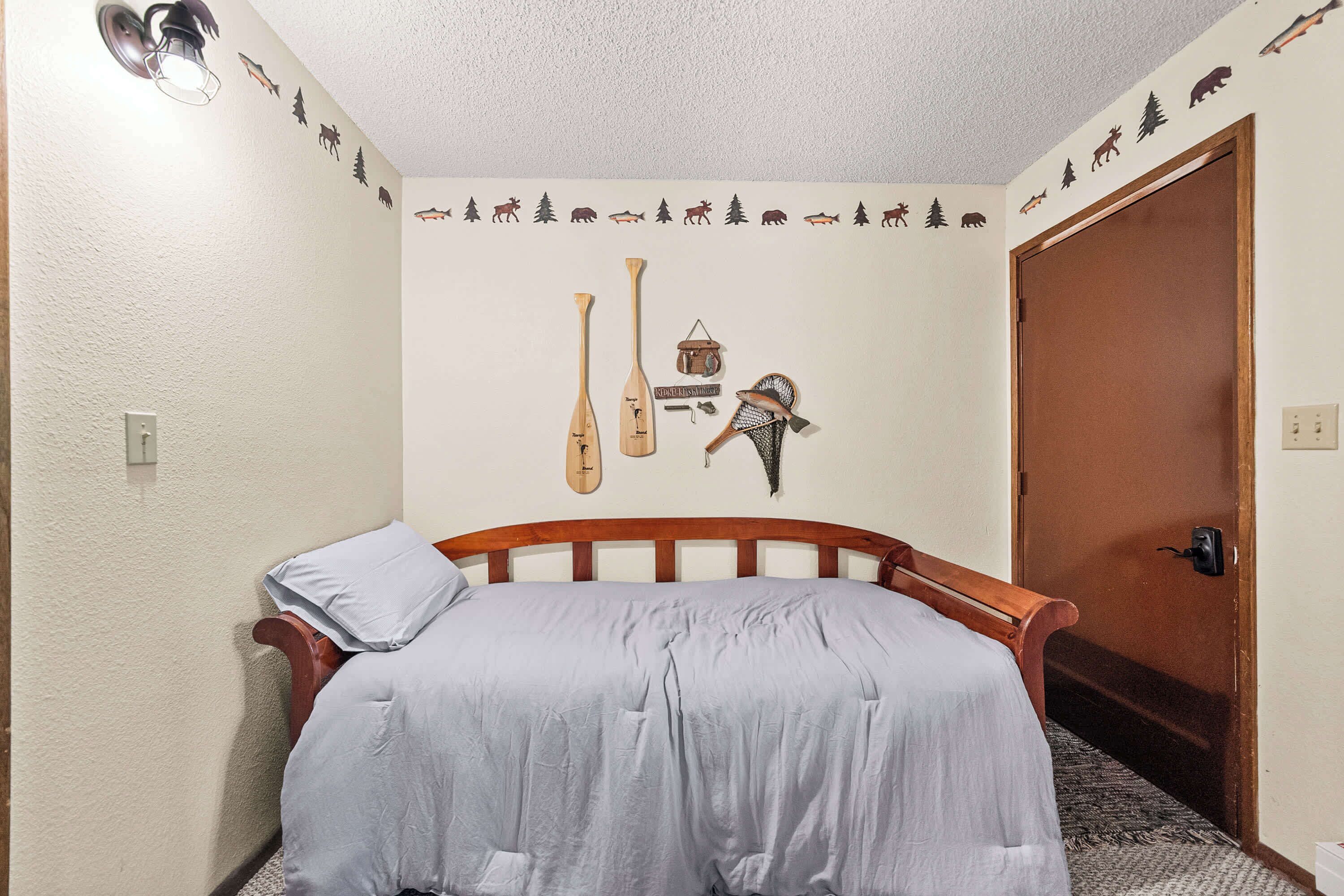 Ein Schlafzimmer mit einem Bett, einer Wanddekoration mit Fischmotiv und einer Tür.