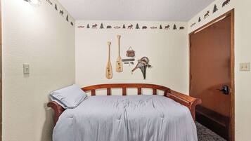 Un dormitorio con cama, un adorno de peces en la pared y una puerta.
