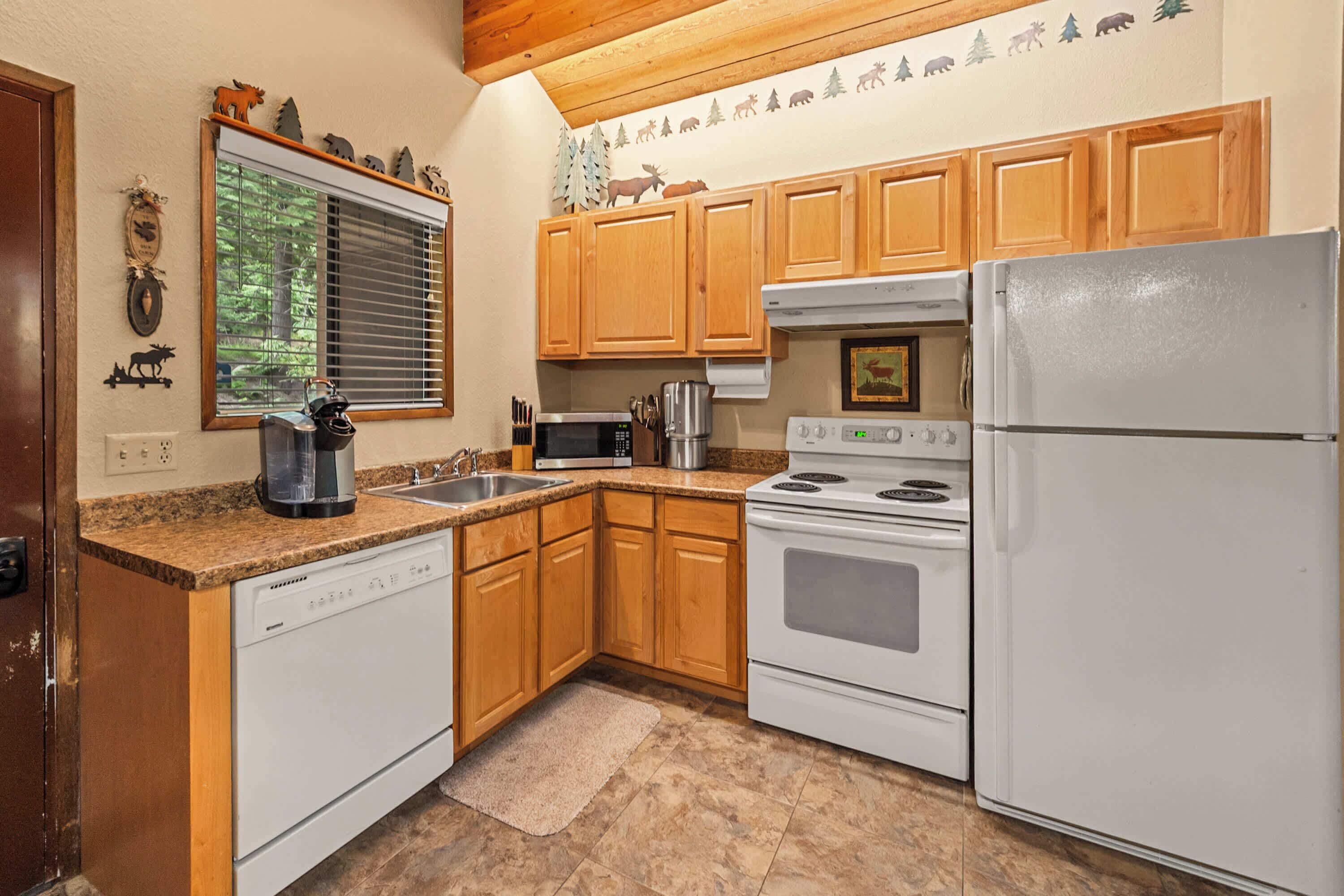 A kitchen with wooden cabinets, a white dishwasher, a stove, and a refrigerator.