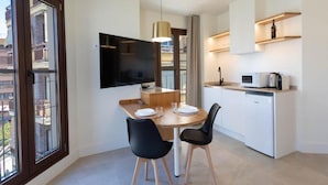 A modern kitchen with a dining area, a flat-screen TV, and a view of the outside. - Deluxe Quadruple Apartment (Alicante)