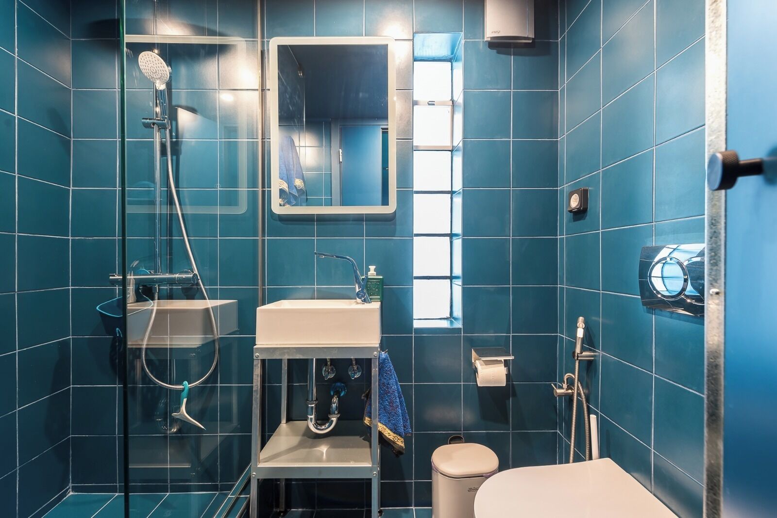 Une salle de bain avec une douche à parois de verre, un lavabo, des toilettes et un miroir.