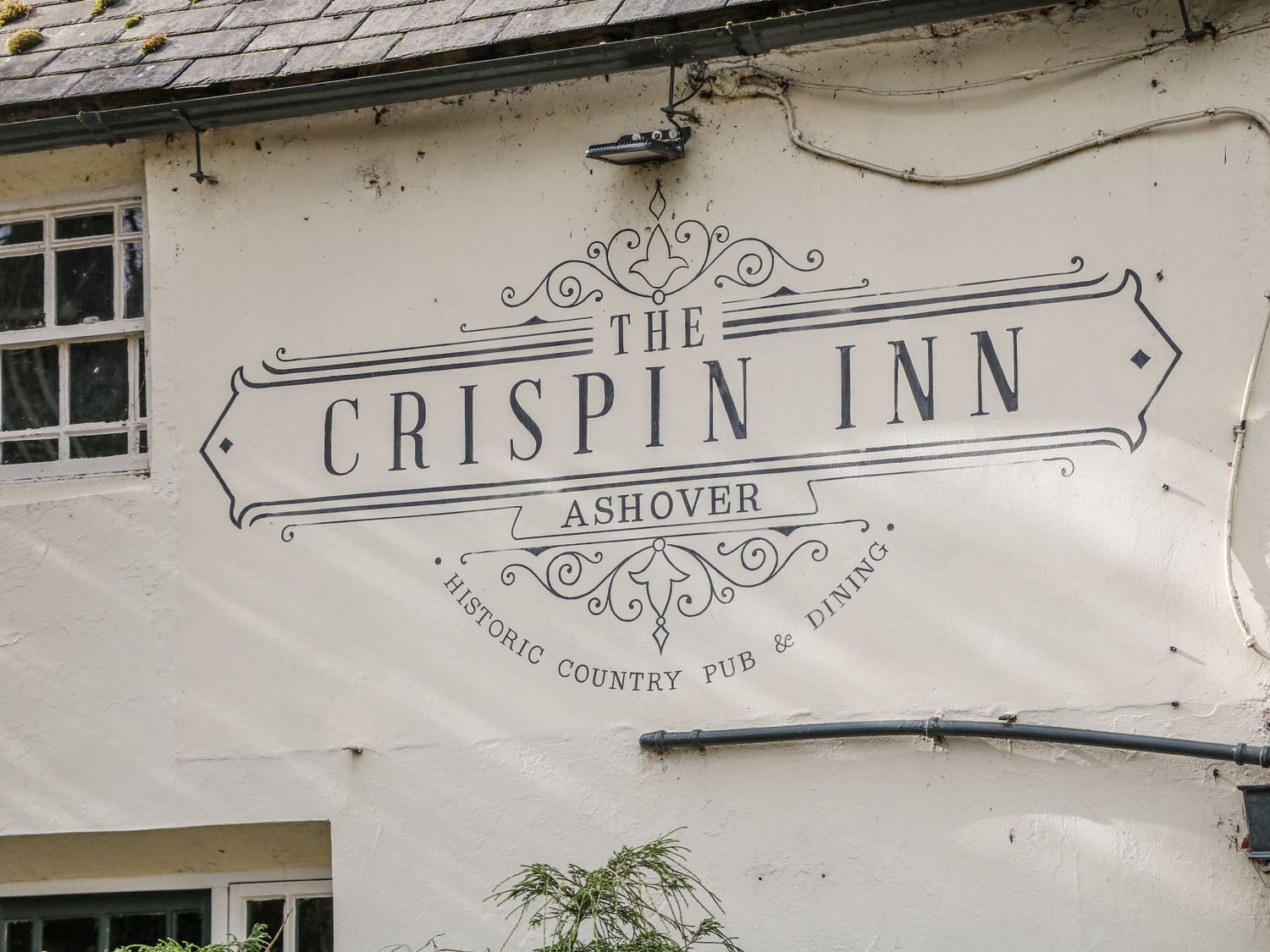 Un edificio con un cartel que dice 'The Crispin Inn Ashover Historic Country Pub & Dining'.