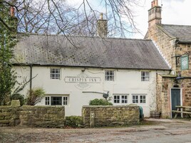A traditional stone building with a sign reading 'The Crispin Inn Ashover.'