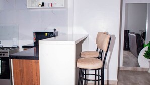 Una cocina moderna con una isla central, taburetes de bar y una estufa.