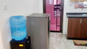 Una cocina con refrigerador, dispensador de agua y un armario de madera.