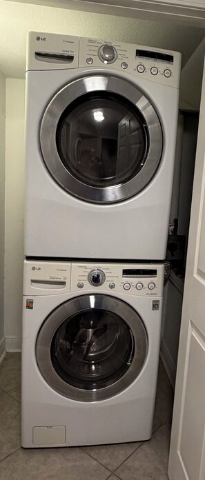 Two stacked front-loading LG washing machines in a laundry room. - Safe & Sound (Biloxi)