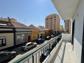 A narrow street with parked cars and buildings on both sides. - Faro Central 1 by Homing (Faro)