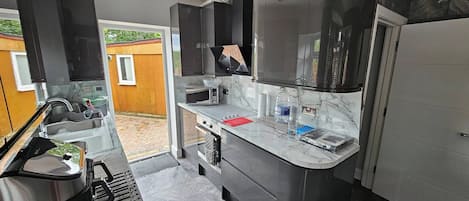 A modern kitchen with a built-in oven, microwave, and a large island with a sink.