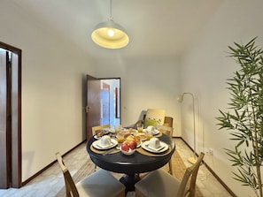 A dining area with a round table, chairs, and a hanging light fixture. - FARO CENTRAL 1 by HOMING (Faro)