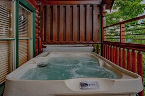 A hot tub with a digital temperature display, surrounded by wooden railings and a window with blinds. - The Cats' Lair: Spectacular Views, Hot Tub, Wifi, Game Room, Resort Pool (Pigeon Forge)