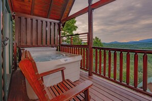 A wooden deck with a hot tub and a bench, overlooking a mountainous landscape. - The Cats' Lair: Spectacular Views, Hot Tub, Wifi, Game Room, Resort Pool (Pigeon Forge)