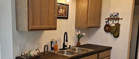Una cocina con armarios de madera, un lavamanos doble y una encimera.