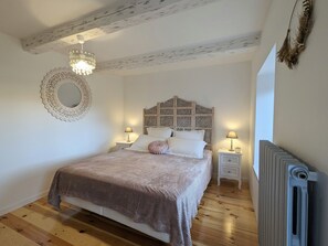 A bedroom with a wooden bed, two bedside tables, a round mirror, and a radiator. - Country house - 15 guests - Loire Valley (Retournac)