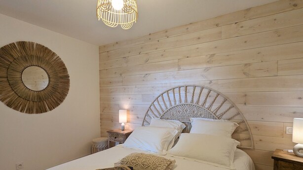 A bedroom with a wooden headboard, a round mirror, a bedside lamp, and a bed with white bedding. - Country house - 15 guests - Loire Valley (Retournac)