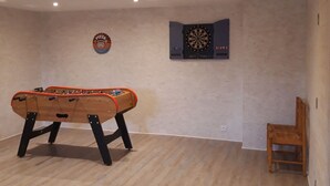 A room with a foosball table, a dartboard, and a pizza-themed wall decoration. - Country house - 15 guests - Loire Valley (Retournac)
