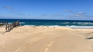 A sandy beach with a wooden boardwalk leading to the ocean. - Modern apartment with parking - 4 guests (Mimizan)