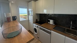 Une cuisine moderne dotée d’appareils électroménagers intégrés, d’une fenêtre offrant une belle vue et d’un plan de travail en bois.