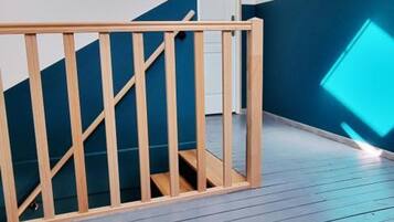 A wooden staircase with a blue wall and a light-colored floor.