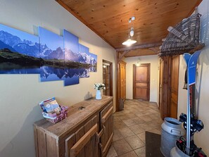 Ein Holzkamin mit einer Bank, einer Blumenvase und einer Wand mit Berglandschaft.