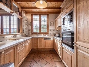 A kitchen with wooden cabinets, a tiled backsplash, and a built-in oven. - Spacious chalet near slopes - 10 guests (Courchevel)