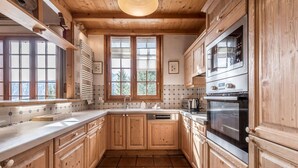 Eine Küche mit Holzausstattung, einer gefliesten Spritzschutzwand und einem eingebauten Backofen.