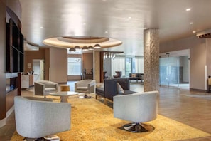 Un'ampia hall con arredi moderni, un lampadario centrale e una reception.