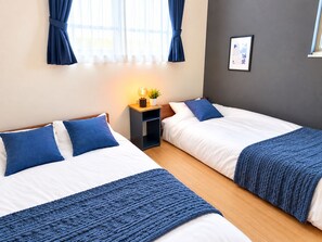 A hotel room with two beds, a bedside table with a lamp, and a framed picture on the wall. - MSTAY Ikebukuro One (Toshima-ku)
