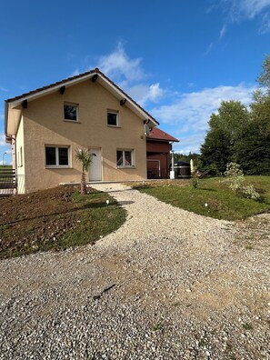 Uma casa de dois andares com um caminho de cascalho que leva à entrada.