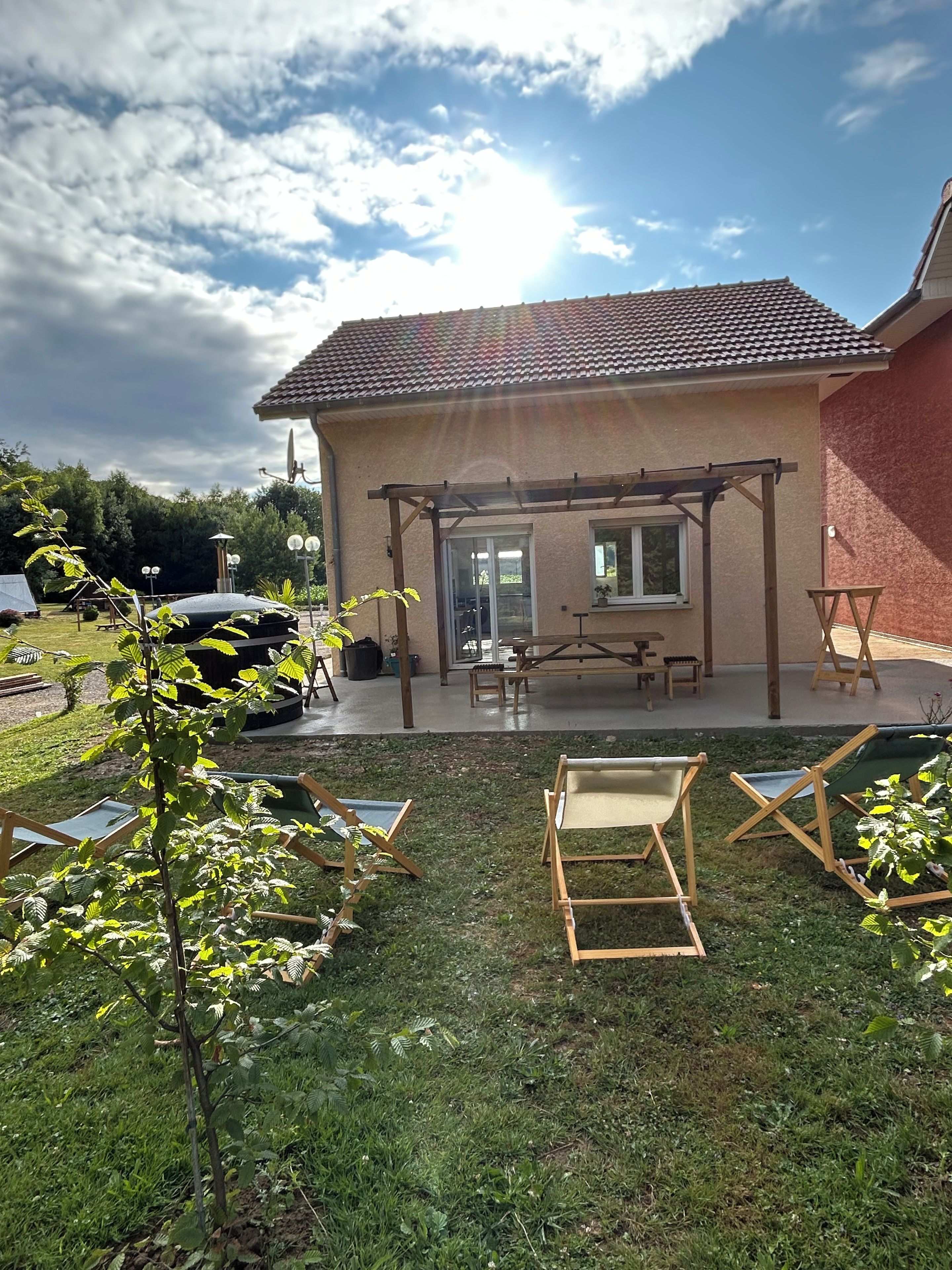 Une maison dotée d’un patio couvert, d’une pelouse et de mobilier d’extérieur.