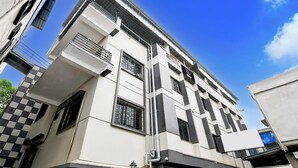 A multi-story building with a modern architectural design, featuring a series of balconies and large windows. - Super Collection O Behala (Alipur)