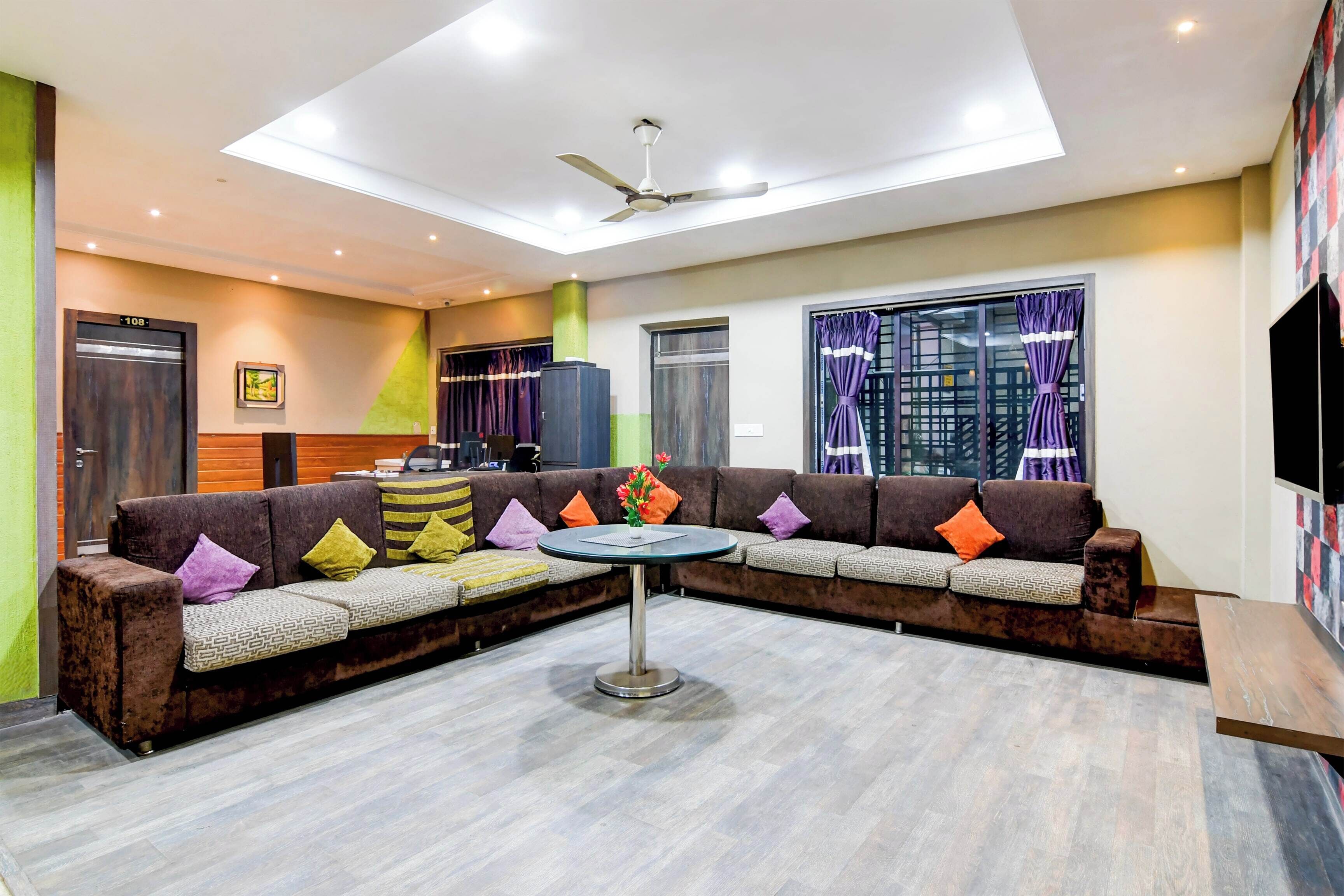 A modern living room with a sectional sofa, a round coffee table, and a ceiling fan.