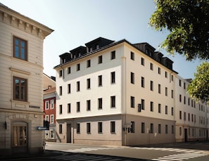 A multi-story building with a flat facade, multiple windows, and a visible entrance.