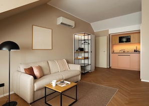 A modern living room with a sofa, a coffee table, a floor lamp, and a bookshelf.