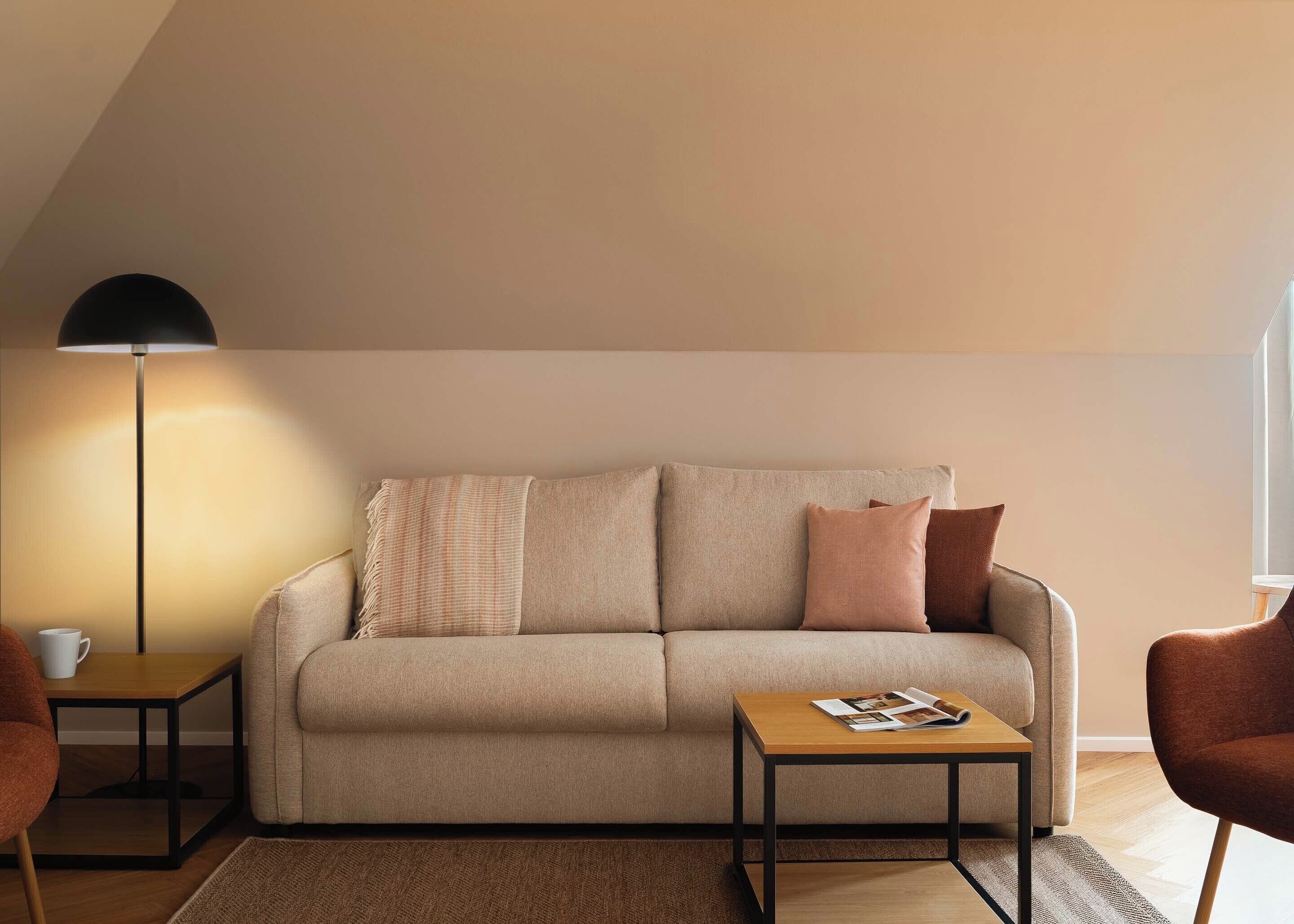 En moderne stue med sofa, to sofaborde, et sofabord og en gulvlampe.
