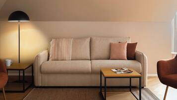 En moderne stue med sofa, to sofaborde, et sofabord og en gulvlampe.