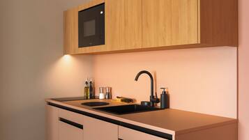 Eine moderne Küche mit einem schwarzen Spülbecken, Holzschränken und einem eingebauten Backofen.