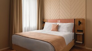 A hotel room with a bed, a nightstand, and a wall with a geometric pattern. - Limehome Linz Urfahr (Linz)