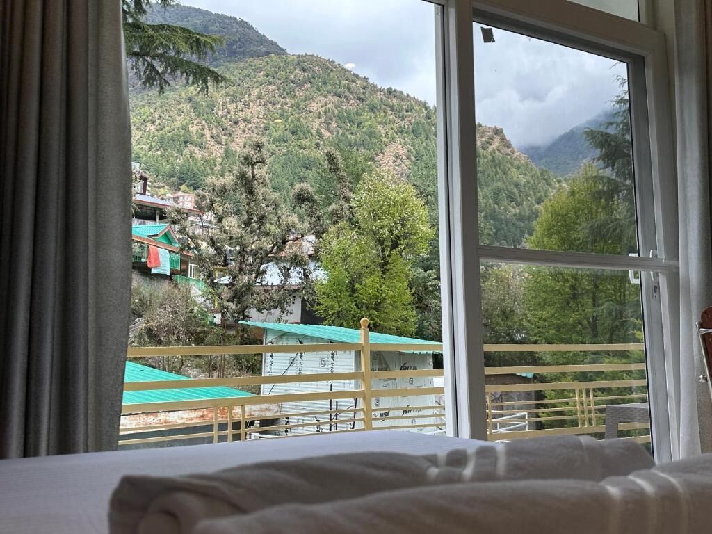 A room with a large window overlooking a mountainous landscape.